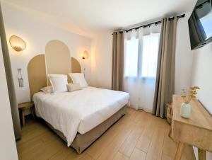 a bedroom with a bed and a large window at Hôtel Flor in Saint-Florent