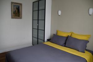 1 dormitorio con 1 cama con almohadas azules y amarillas en Le clos argoat en Pontivy