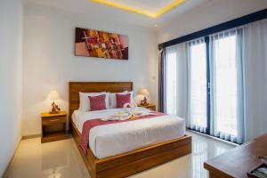 sypialnia z łóżkiem i dużym oknem w obiekcie Penida Paradiso w mieście Klungkung