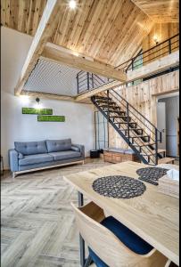 a living room with a blue couch and a wooden staircase at Norway Cabins in Sinaia