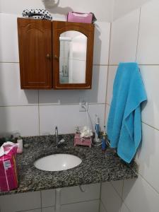 a bathroom counter with a sink and a blue towel at Casa Piratininga Niterói Rj in Niterói