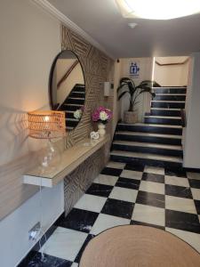 Hotel Mariquito في فينيستيري: غرفة مع درج مع مرآة وأرضية لوح خشب