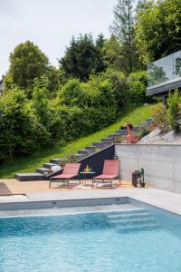 een zwembad met twee stoelen naast een huis bij LA Villa Du Lac in Annecy