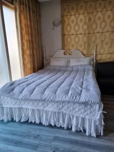 a white bed in a room with a window at Haeansung Pension in Seogwipo