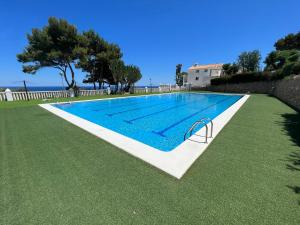 ein großer Pool in einem Garten mit grünem Gras in der Unterkunft GranAlacantHoliday mit traumhaften Meerblick und grossem Pool in Gran Alacant