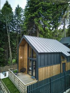 una casa pequeña con techo de metal y terraza en Norway Cabins en Sinaia