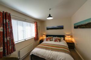 a bedroom with a bed with two lamps and a window at Sail Loft in Camber