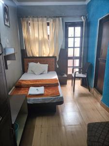a small bedroom with a bed and a window at Hotel City Plaza in Dharamshala