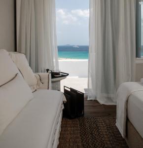 アギオス・プロコピオスにあるSea U Soon Seafront Suitesのベッドが2つあり、海が見えるベッドルーム