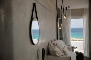 アギオス・プロコピオスにあるSea U Soon Seafront Suitesのリビングルーム(椅子、鏡付)