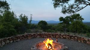 a fire pit in front of a stone wall at 203 Zebula - 5 Bedroom 20 sleeper in Mabula