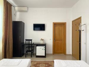 Cette chambre comprend un bureau et une table avec une chaise. dans l'établissement Guesthouse Niko, à Berat