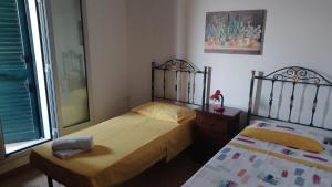 ein Schlafzimmer mit zwei Betten und einem Spiegel in der Unterkunft Residence Ginevra-Porto Miggiano in Santa Cesarea Terme + 60 Fotos