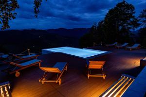 a table and chairs on a deck at night at StockEstate Moieciu in Moieciu de Jos