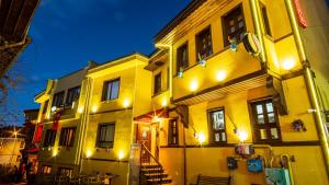 un edificio amarillo con luces encendidas por la noche en La Vie Konak Otel, en Eskisehir
