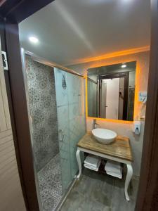 a bathroom with a sink and a shower with a mirror at La Vie Konak Otel in Eskisehir