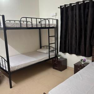 een kamer met 2 stapelbedden en een raam bij Elite stays in Pune