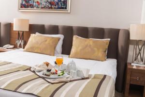 a hotel room with a breakfast tray on a bed at Grannos Thermal Hotel & Convention Center in Haymana +88 photos
