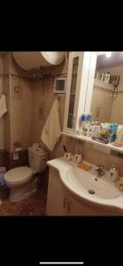 a bathroom with a sink and a toilet and a mirror at SEA HOUSE KOUKOULEIKA in Milina