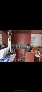a kitchen with wooden cabinets and a counter top at SEA HOUSE KOUKOULEIKA in Milina