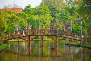 un pont sur une rivière avec un canard sous celle-ci dans l'établissement Golden Pine Resort and Spa, à Ban Du