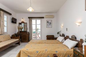 1 dormitorio con 2 camas y sofá en Golden Silence Studios, en Agios Prokopios