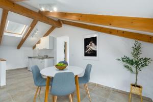 a kitchen and dining room with a white table and blue chairs at Apartments Agata in Novigrad Istria