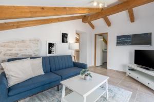 a living room with a blue couch and a tv at Apartments Agata in Novigrad Istria