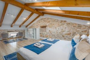 a bedroom with a large bed and a stone wall at Apartments Agata in Novigrad Istria