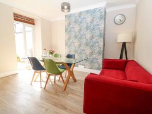 uma sala de estar com um sofá vermelho e uma mesa em Llandudno 3 Bedroom Holiday Apartment in Town Centre em Llandudno