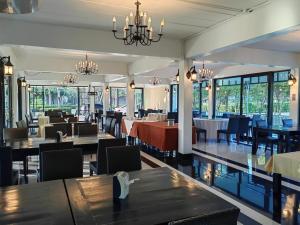 尖竹汶แกรนด์ ฟอเรสท์ Grand Forest的有桌椅和窗户的餐厅