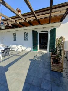 um pátio com uma pérgola de madeira e uma mesa em Residenza Casa Bianca em Marina di Massa