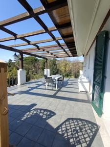 eine Terrasse mit einem Tisch und Stühlen unter einer Pergola in der Unterkunft Residenza Casa Bianca in Marina di Massa