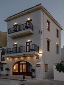 a large white building with two balconies on it at Ethos Suites in Chania +28 photos