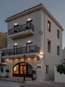 a large white building with two balconies on it at Ethos Suites in Chania