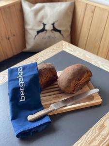 a tray with two loaves of bread and a knife at Hotel Bergalga in Am Bach