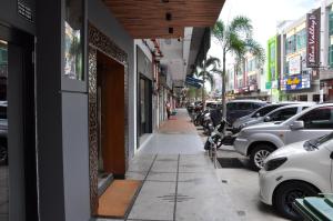 eine Straße mit Autos, die an der Seite eines Gebäudes geparkt sind in der Unterkunft Valya Hotel, Kuala Terengganu in Kuala Terengganu