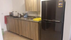 a kitchen with a black refrigerator and a sink at casa di nonna in Hurghada