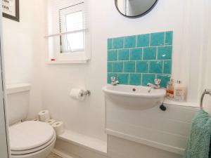 uma casa de banho branca com um WC e um lavatório em Llandudno 3 Bedroom Holiday Apartment in Town Centre em Llandudno
