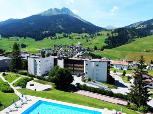 a resort with a swimming pool and mountains in the background at Penthouse Tgesa Tgampi T33 in Savognin