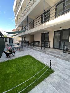 a large building with a patio with grass in front of it at Vila 69 in Costinesti