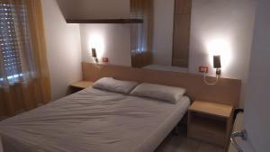 a small bedroom with a bed and a mirror at Quadrifoglio 43 in Bibione