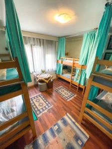 Hi Skopje Hostel في إسكوبية: غرفة بسريرين بطابقين وأرضيات خشبية