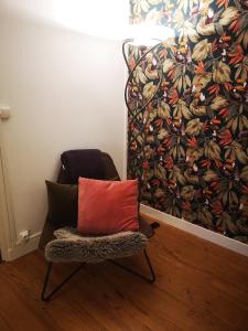 een stoel met een rood kussen voor een muur bij LE HARAS in Libourne