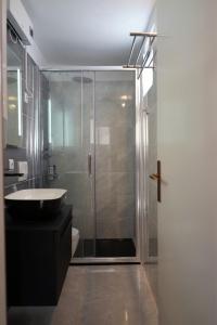a bathroom with a glass shower and a sink at Toma Apartman in Bilice