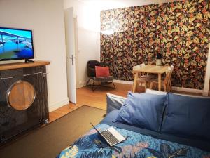 een woonkamer met een bank en een tv bij LE HARAS in Libourne