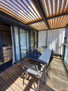 a patio with a table and chairs on a deck at Bruse & Costa à la montagne 2 in Chorges