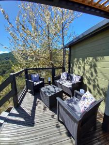 a deck with wicker chairs and tables with a view at Bruse & Costa à la montagne 2 in Chorges