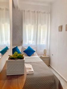 - une chambre avec un lit doté d'oreillers bleus et d'une table dans l'établissement Mokamvilia House, à Amoliani