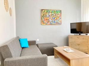 a living room with a couch and a flat screen tv at Mokamvilia House in Ammouliani